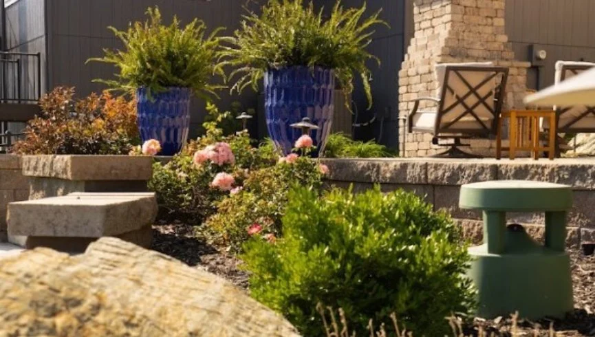 Outdoor living space with a fire pit and boulder retaining wall in Leawood, KS.