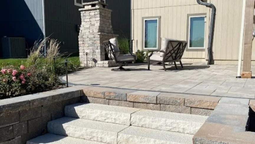 Outdoor living space with a fire pit and boulder retaining wall in Leawood, KS.
